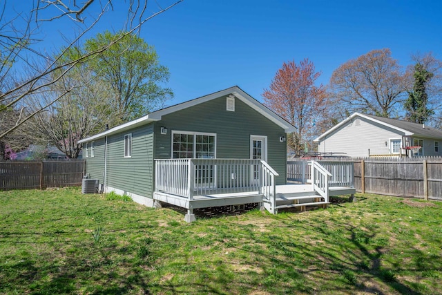 rear view of house featuring a fenced backyard, a wooden deck, a yard, and central AC