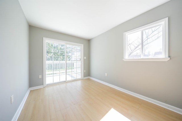 unfurnished room featuring baseboards and light wood-style floors