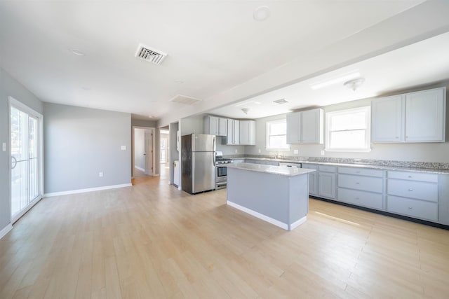 kitchen with a center island, visible vents, light wood-style floors, and appliances with stainless steel finishes