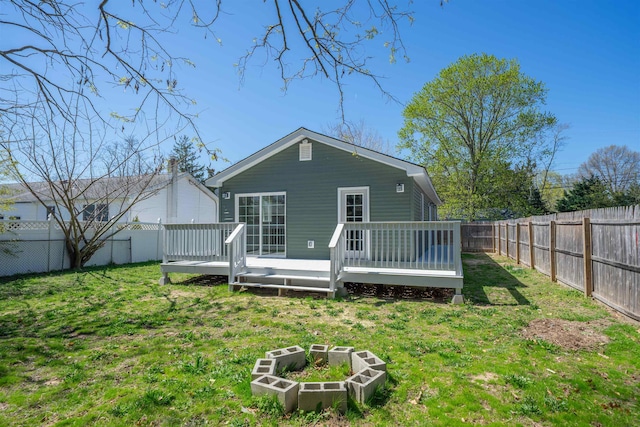 back of house with a yard, a fenced backyard, and a deck