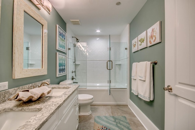 full bathroom featuring tile patterned floors, vanity, toilet, and bath / shower combo with glass door