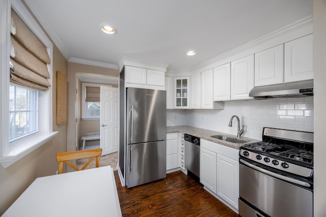 kitchen featuring white cabinets, stainless steel appliances, crown molding, under cabinet range hood, and a sink