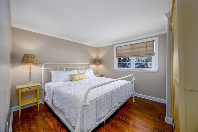 bedroom with ornamental molding, wood finished floors, and baseboards