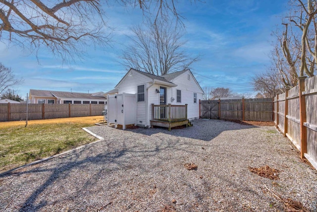 rear view of house with a deck, a yard, and a fenced backyard