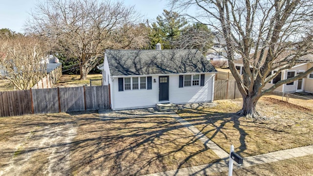 view of front of house with entry steps, a shingled roof, an outdoor structure, and fence