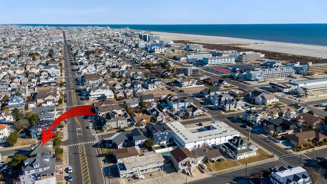 birds eye view of property featuring a beach view and a water view