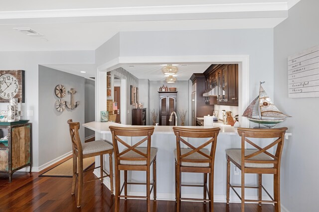 9601 Atlantic Ave Unit 310, Lower Township, NJ 08260 - kitchen featuring dark wood-style flooring, baseboards, a breakfast bar area, dark brown cabinets, and a peninsula