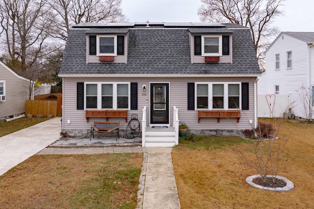 view of front of house with solar panels and a front yard