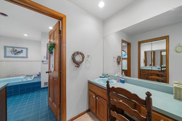 bathroom featuring tile patterned flooring, vanity, and a relaxing tiled tub