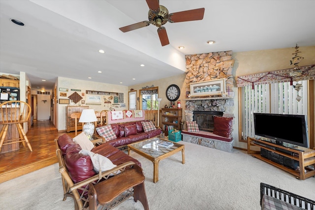 living room featuring vaulted ceiling, a stone fireplace, and ceiling fan