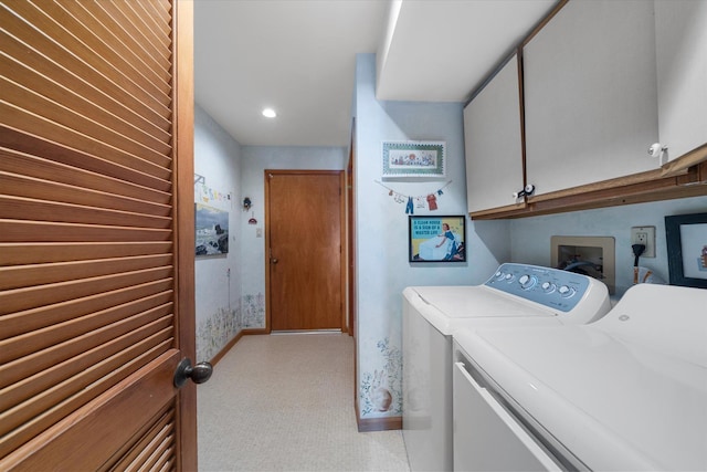 clothes washing area with cabinets and washing machine and clothes dryer