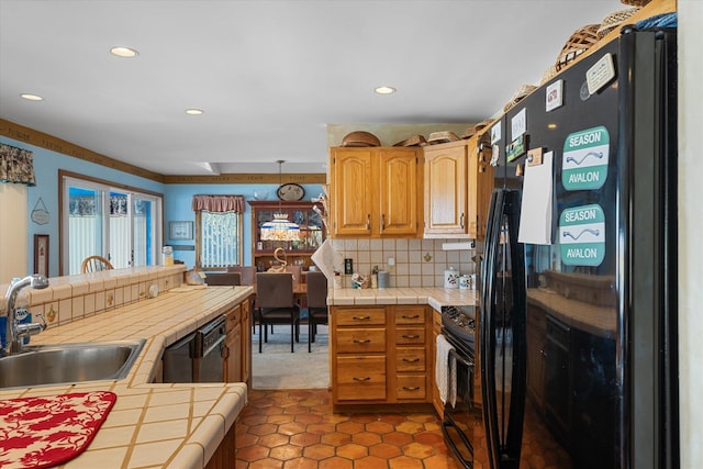 kitchen featuring tasteful backsplash, tile counters, black appliances, and sink