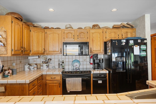 kitchen with decorative backsplash, tile counters, and black appliances