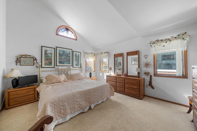 carpeted bedroom with high vaulted ceiling