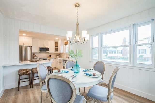 6110 Seaview Ave, Wildwood Crest, NJ 08260 - dining room featuring light wood-type flooring, a chandelier, and a decorative wall