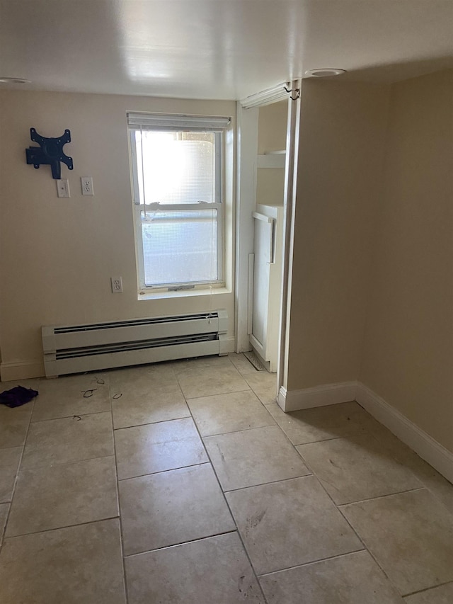 interior space featuring light tile patterned floors, a baseboard radiator, and baseboards