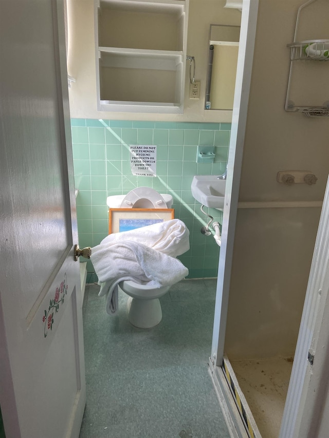 bathroom with a stall shower, tile walls, and a wainscoted wall