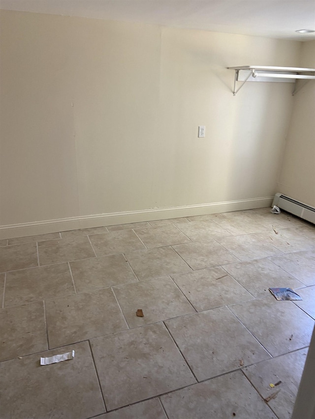 laundry room with light tile patterned floors, baseboards, and a baseboard heating unit