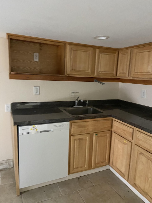 kitchen with a sink, dark countertops, tile patterned flooring, and dishwasher