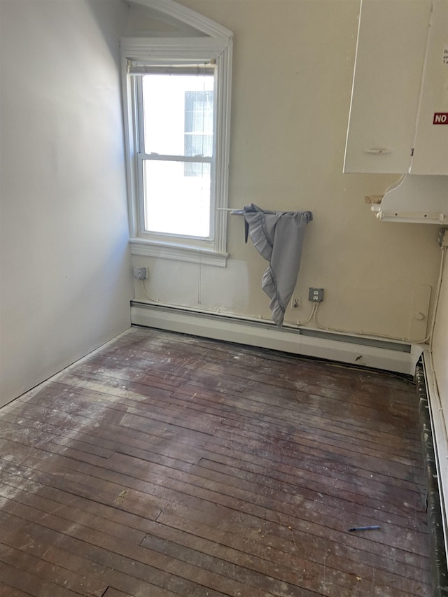 unfurnished room with baseboard heating, hardwood / wood-style floors, and a baseboard radiator