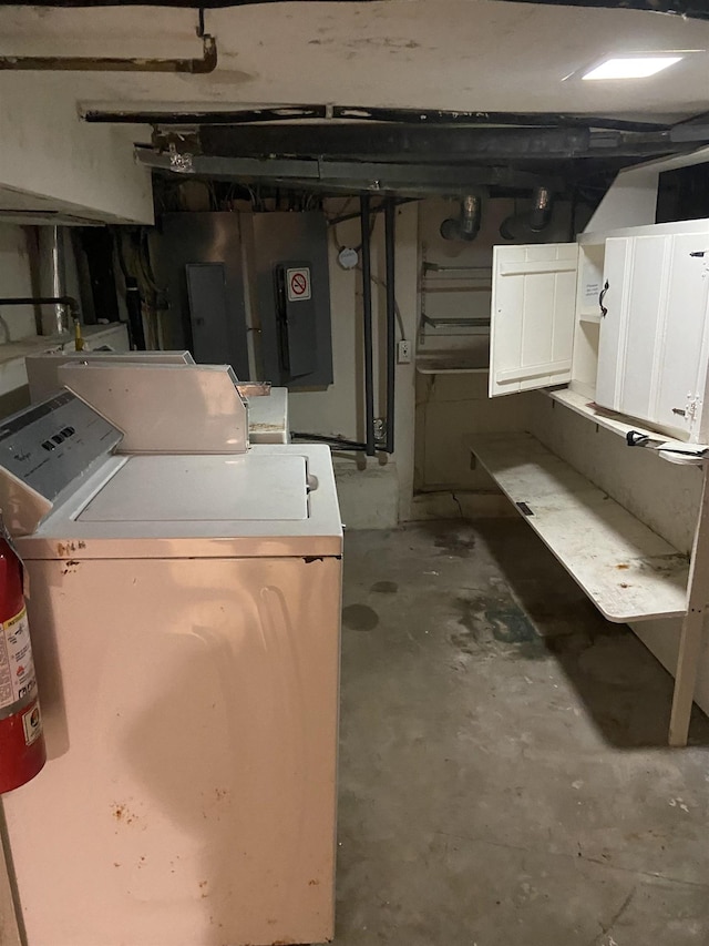 unfinished basement featuring washing machine and clothes dryer and electric panel