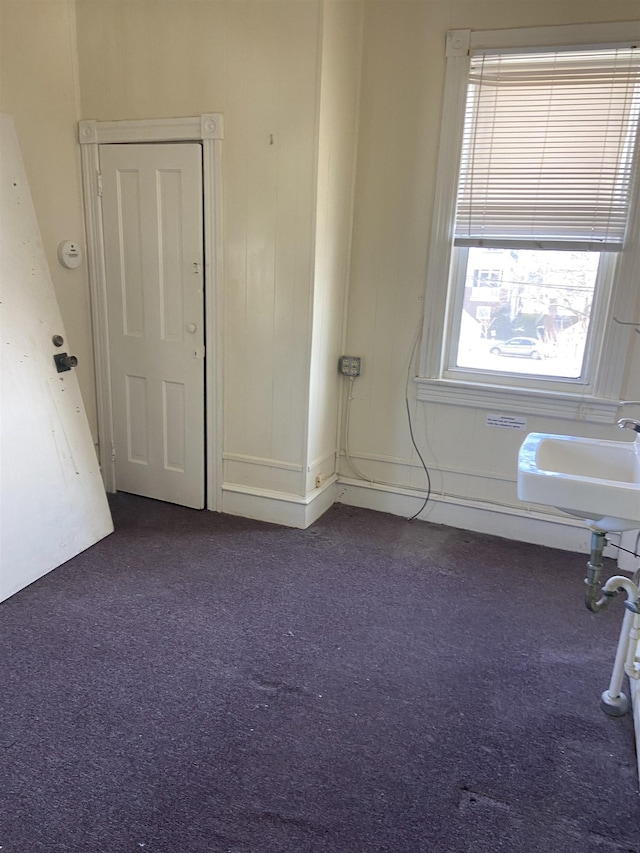empty room with a sink and dark carpet