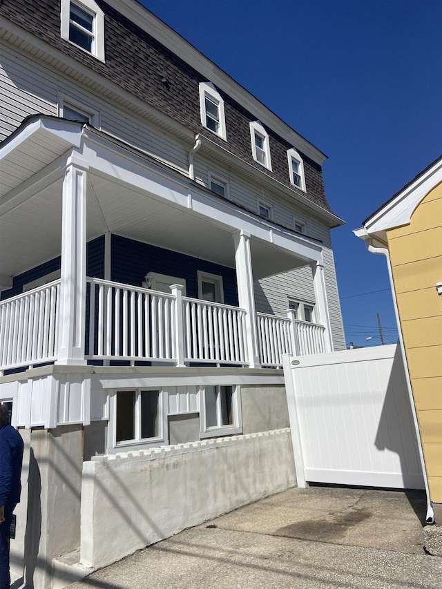 exterior space featuring a shingled roof and mansard roof