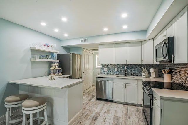 405 Ocean Ave Unit 110, North Wildwood, NJ 08260 - kitchen with stainless steel appliances, a peninsula, tasteful backsplash, a breakfast bar area, and recessed lighting