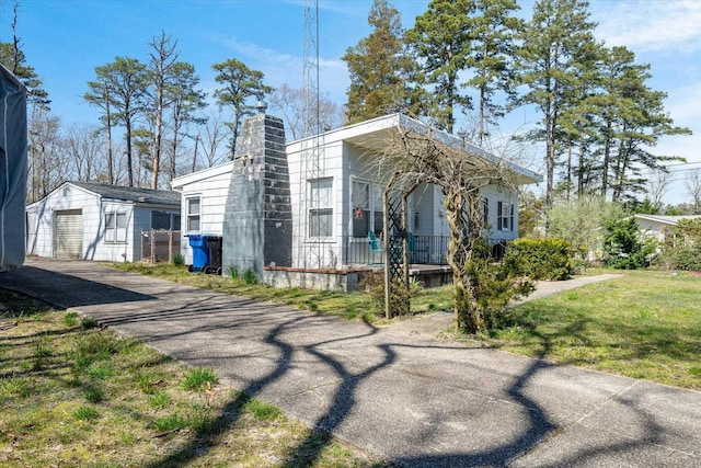 view of front of house with a front yard, a garage, and an outdoor structure