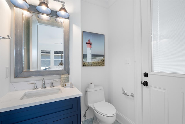 bathroom with a healthy amount of sunlight, vanity, and toilet