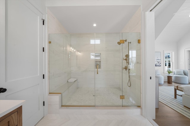 bathroom with walk in shower, vanity, vaulted ceiling, and hardwood / wood-style floors