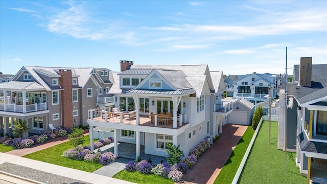 back of house with a balcony and a lawn