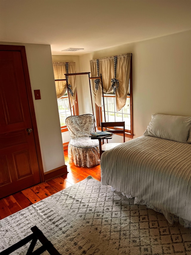 bedroom featuring wood-type flooring and multiple windows