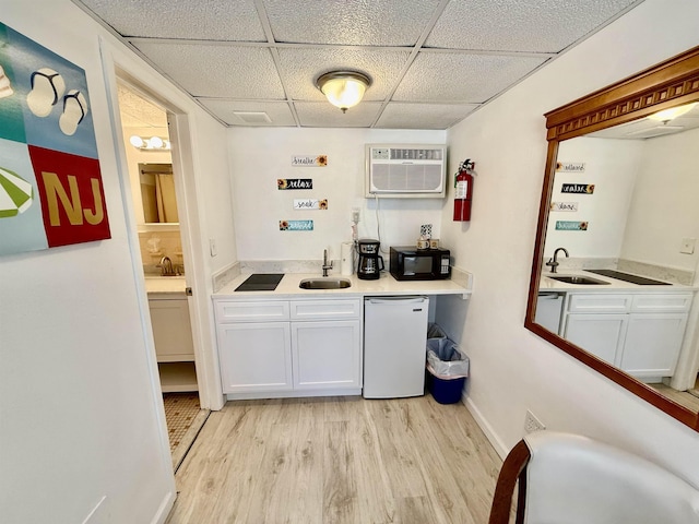 bar featuring light wood-style floors, black microwave, a sink, and fridge