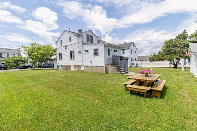 rear view of property with a lawn