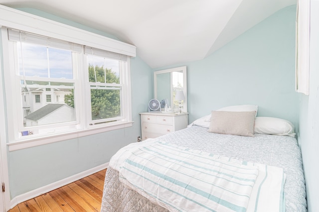 bedroom with light hardwood / wood-style floors and vaulted ceiling