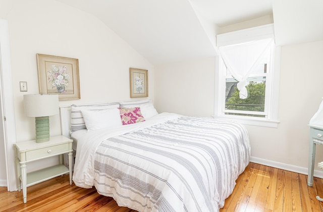 bedroom with lofted ceiling and hardwood / wood-style flooring