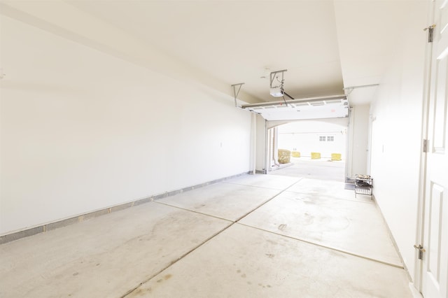 garage featuring a garage door opener and baseboards