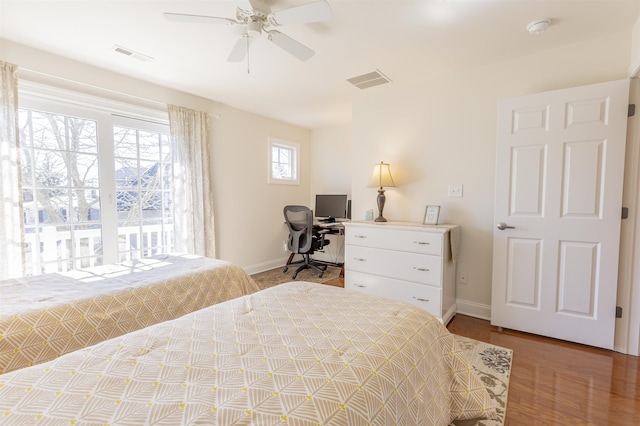 bedroom featuring a ceiling fan, wood finished floors, baseboards, and visible vents