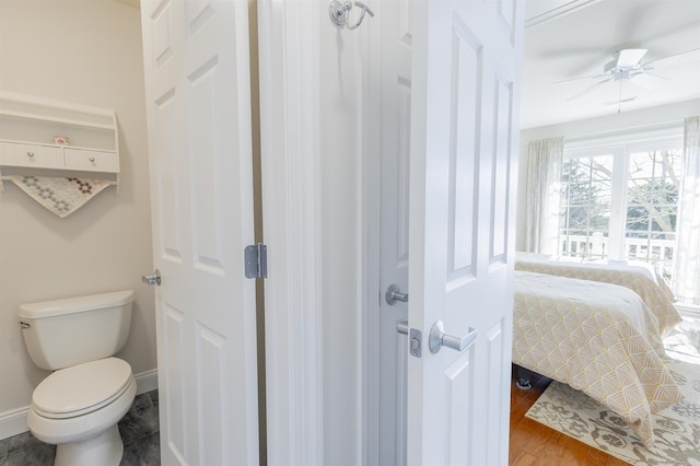 bathroom with ceiling fan, baseboards, toilet, and wood finished floors