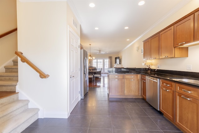 kitchen with crown molding, open floor plan, appliances with stainless steel finishes, a peninsula, and brown cabinetry