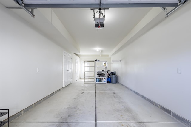 garage featuring a garage door opener and baseboards