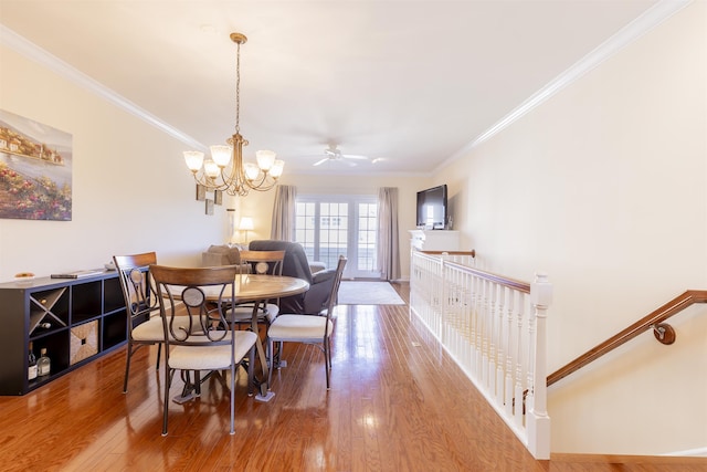 dining space featuring an inviting chandelier, wood finished floors, and ornamental molding