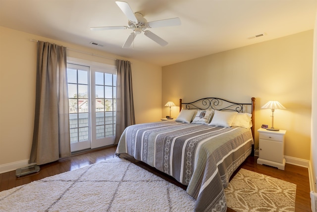 bedroom featuring visible vents, wood finished floors, baseboards, and access to outside