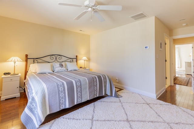 bedroom featuring visible vents, baseboards, ceiling fan, and hardwood / wood-style flooring