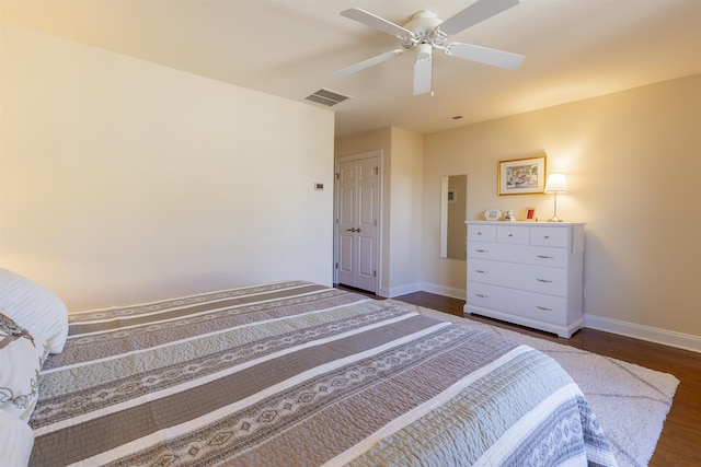 bedroom featuring visible vents, a ceiling fan, baseboards, and dark wood-style flooring