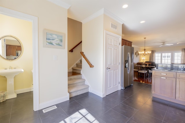 kitchen featuring decorative light fixtures, visible vents, stainless steel fridge with ice dispenser, and crown molding