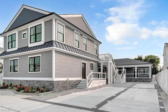 view of front of property with a porch, fence, metal roof, and a standing seam roof