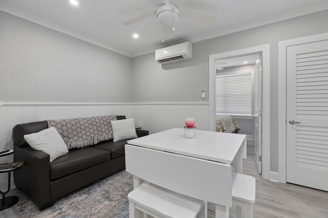 living room with ceiling fan, wainscoting, light wood finished floors, an AC wall unit, and recessed lighting