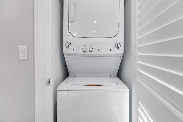clothes washing area with laundry area and stacked washer and dryer